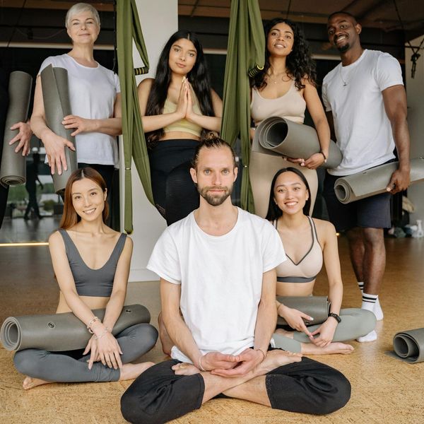 Group of diverse people smiling during a yoga class break.